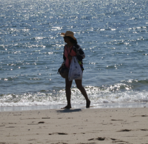 A woman walks on a beach in Truro, Massachusetts on Cape Cod, the site, three years ago, of a non-fatal shark attack.