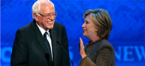 Hillary Clinton, right, talks to Bernie Sanders during a break in the Democratic Debate December 19, 2015, at St. Anselm College in Manchester, New Hampshire (Courtesy AP via Fox News)